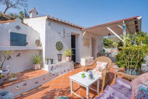 a patio with a table and chairs on a house at Cortijo La Alamea in Almuñécar