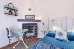 a bedroom with a bed and a table and chairs at Cortijo La Alamea in Almuñécar