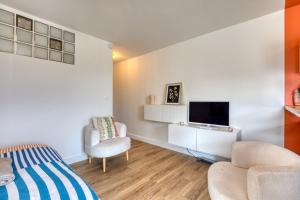 a bedroom with a bed and a tv and a chair at Sunny Day in La Grande Motte