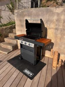 a barbecue grill sitting on a wooden deck at Maison Corsica vue mer exceptionnel in Cervione