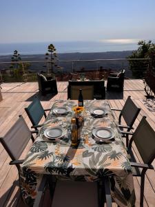 a table with plates and a bottle of wine on a patio at Maison Corsica vue mer exceptionnel in Cervione