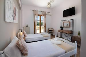 two beds in a room with a tv and a mirror at Maestro Apartment 2 in Vlachopoulátika