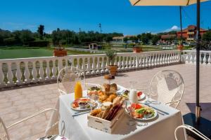 a table with plates of food on a balcony at Maestro Apartment 2 in Vlachopoulátika