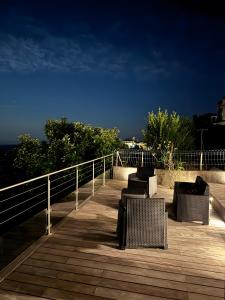 a group of chairs sitting on a wooden deck at Maison Corsica vue mer exceptionnel in Cervione