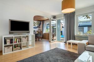 a living room with a flat screen tv on a white entertainment center at Casa Noho in Nonnenhorn