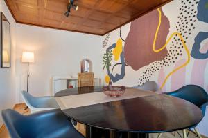 a dining room with a table and blue chairs at Casa Noho in Nonnenhorn