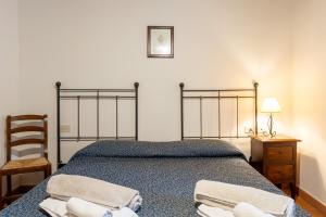 a bedroom with a bed with two towels on it at Apartament Monastero in Cortona +25 photos