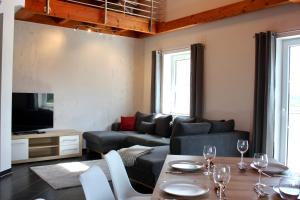 a living room with a couch and a table with wine glasses at Fewo Feldblick in Merkendorf