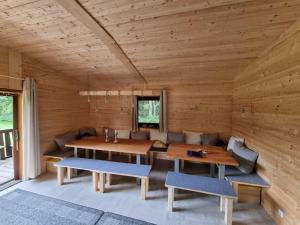 a wooden room with a wooden table and benches at Weiherhüttla in Untersteinach