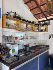 a kitchen with a sink and a counter top at Pousada Marauá - Na beira do mar de Cumuru in Cumuruxatiba