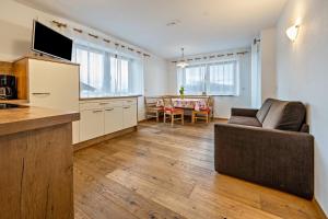 a kitchen and living room with a couch and a table at Maurerhof Morgenrot in Maranza
