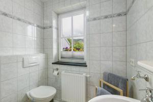 a bathroom with a toilet and a window at Chalet Sonnenhügel in Schmallenberg +14 photos