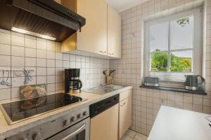 a kitchen with a stove and a sink and a window at Chalet Sonnenhügel in Schmallenberg
