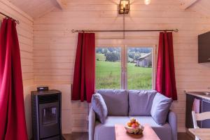 a living room with a couch and a window at Sundowner Cabin in Oberammergau