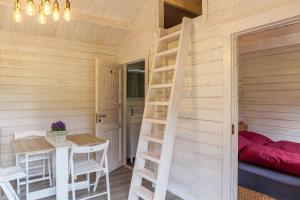 a room with a bed and a table and a ladder at Sundowner Cabin in Oberammergau