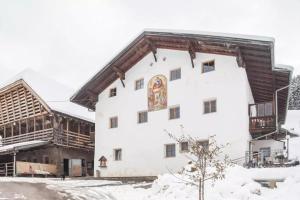 a large white building with a mural on the side at Ladinser Hof Sternenhimmel in Castelrotto +11 photos