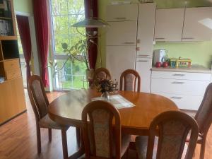 a dining room table with chairs and a kitchen at Im schönen Garten in Haldensleben