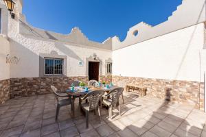 a patio with a table and chairs and a building at La Tierra in Níjar