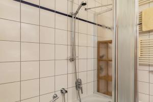a shower in a bathroom with white tiles at Ferienwohnung Tannenblick 2-1 in Oberhof +17 photos