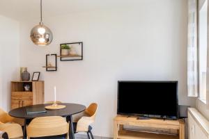 a living room with a table and a flat screen tv at Ferienwohnung Tannenblick 2-1 in Oberhof