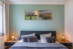 a bedroom with a bed with three pictures on the wall at Ferienwohnung Tannenblick 2-1 in Oberhof