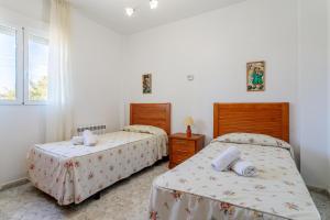 a bedroom with two beds and a window at Chalet Limonita in Mutxamel +22 photos