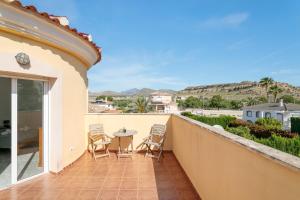 a balcony of a house with a table and chairs at Chalet Limonita in Mutxamel