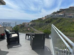 a balcony with chairs and a view of the ocean at Casa do Pico in Ribeira Brava