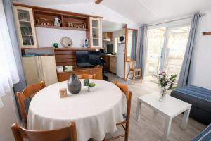a kitchen and living room with a table and chairs at Bungalow Camping 4 étoiles - Mer à pied in Hyères