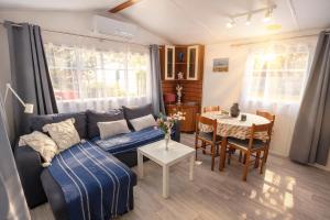 a living room with a couch and a table at Bungalow Camping 4 étoiles - Mer à pied in Hyères