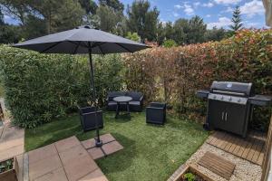 a patio with an umbrella and a grill at Bungalow Camping 4 étoiles - Mer à pied in Hyères +7 photos