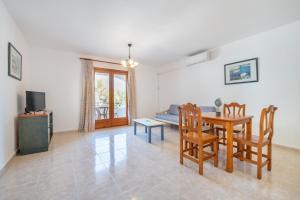 a living room with a table and chairs and a couch at Apartamentos Karin 1ºa in Cala d´Or