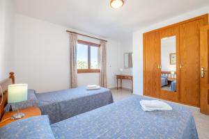 a hotel room with two beds and a mirror at Apartamentos Karin 1ºa in Cala d´Or +17 photos