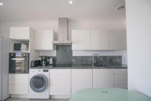 a white kitchen with a washing machine in it at Sublime Appart Neuf in Albitreccia