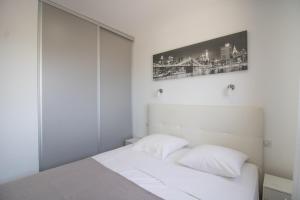 a white bedroom with two pillows on a bed at Sublime Appart Neuf in Albitreccia +18 photos
