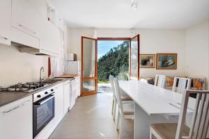 a kitchen with white cabinets and a large window at Villa Del Sole in Bonassola