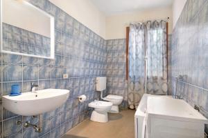a blue tiled bathroom with a sink and a toilet at Villa Del Sole in Bonassola +25 photos