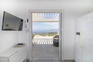 a room with a door leading to a balcony with the ocean at Sublime Appart Neuf in Albitreccia