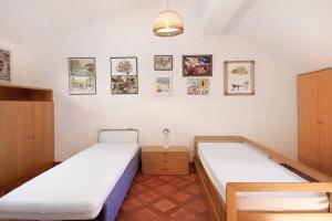 a room with two beds and pictures on the wall at Villa Del Sole in Bonassola