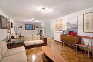 a living room with a couch and a piano at Villa Del Sole in Bonassola