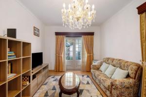 a living room with a couch and a chandelier at Casa Cimo D'Aldeia in Vila Cova de Perrinho