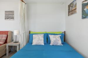 a bedroom with a blue bed and a couch at Boutique Stone Cottage House in Kalymnos