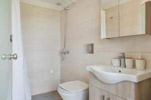 a white bathroom with a sink and a toilet at Boutique Stone Cottage House in Kalymnos +34 photos