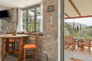 a room with a stone wall and a table and chairs at Boutique Stone Cottage House in Kalymnos