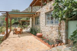 a stone house with a patio and a table at Boutique Stone Cottage House in Kalymnos