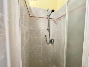 a shower in a bathroom with a tiled wall at Casa Conchiglia in Vado Ligure +9 photos