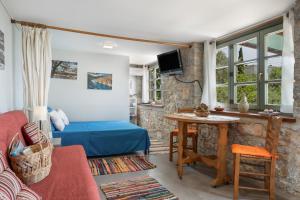 a living room with a bed and a table at Boutique Stone Cottage House in Kalymnos