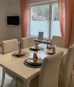 a dining room table with chairs and a large window at Ferienhaus Rübeland in Neuwerk