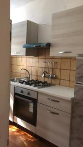a kitchen with a stove and a sink at Casa Nessi- Stanze in Platamona