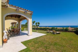 a patio with a table and chairs and the ocean at San Teodoro Villa Ambra Costa Caddu in San Teodoro